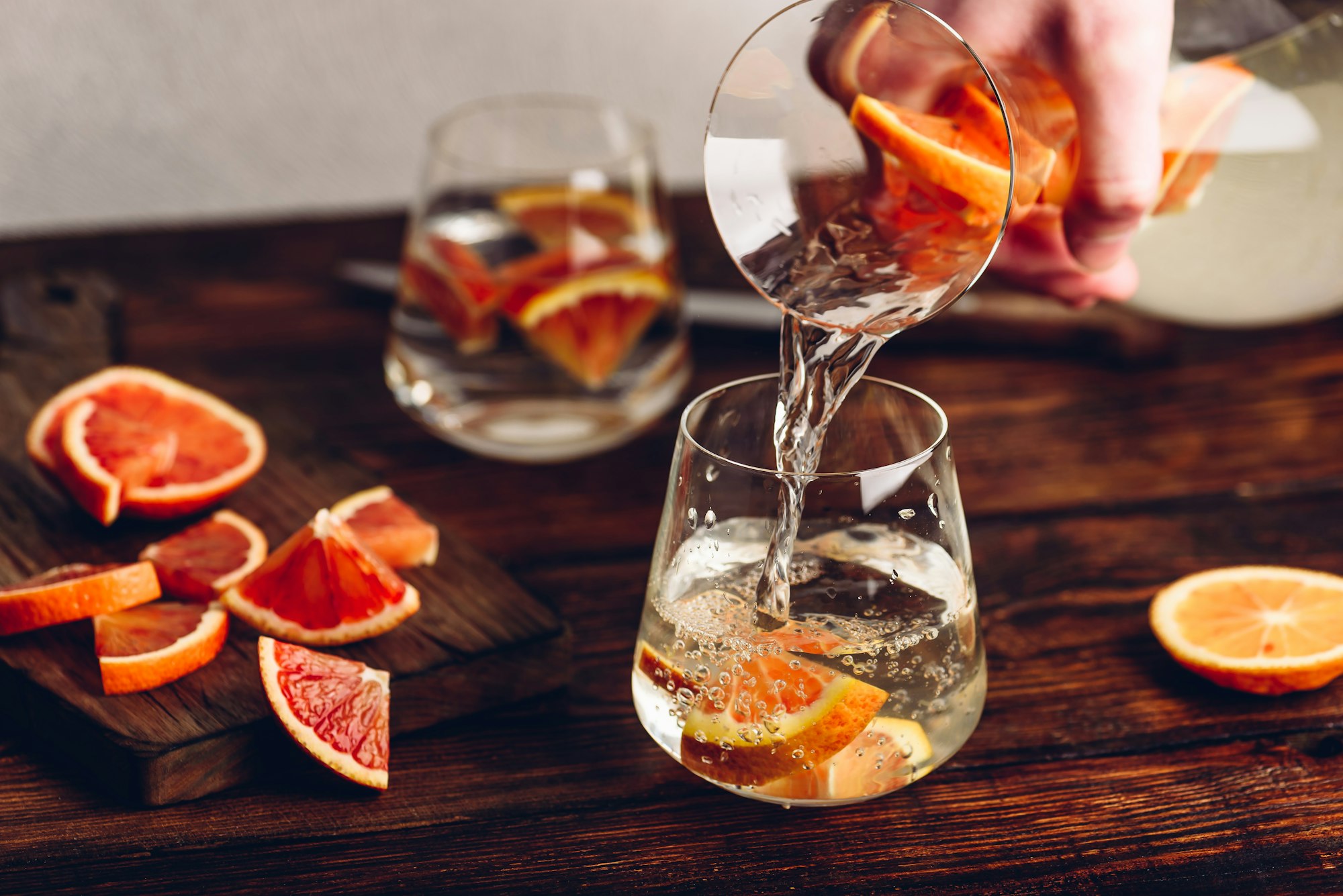 Pouring infused water with oranges into the glass
